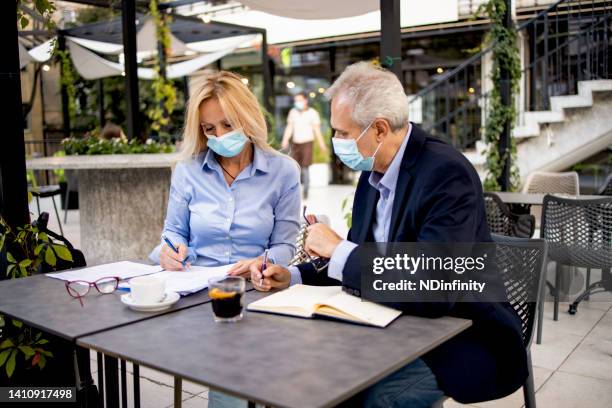 two senior businessmen considering a business plan and sign contract stock photo - business plan covid stock pictures, royalty-free photos & images