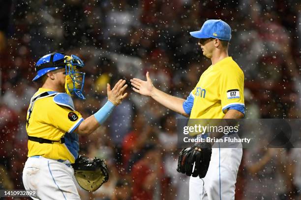 Garrett Whitlock of the Boston Red Sox high-fives Christian Vazquez after defeating the Cleveland Guardians 3-1 at Fenway Park on July 25, 2022 in...