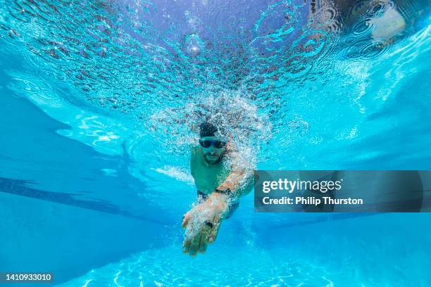 close up of male fitness model swimming laps in an outdoor pool on a sunny day - swimming free style pool stockfoto's en -beelden