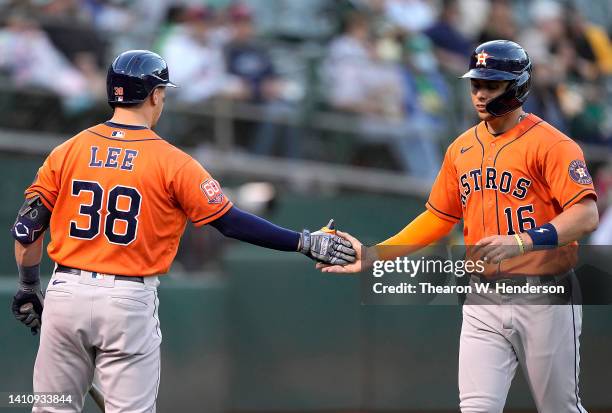 Aledmys Diaz of the Houston Astros is congratulated by Korey Lee after Diaz scored against the Oakland Athletics in the top of the six inning at...