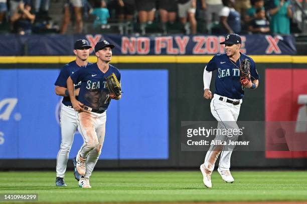 Adam Frazier, Sam Haggerty and Dylan Moore of the Seattle Mariners run off the field after a 4-3 win over the Texas Rangers at T-Mobile Park on July...