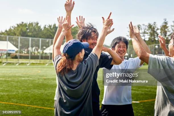 a middle-aged uncle who enjoys playing soccer on holidays. - sports team high five stock pictures, royalty-free photos & images