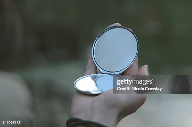 hand holding small silver mirror - hand mirror stock pictures, royalty-free photos & images