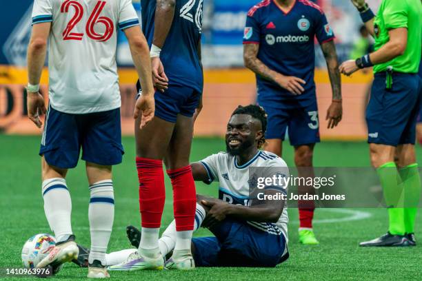 Leonard Owusu of the Vancouver Whitecaps FC receives a helping hand from Jhon Duran of the Chicago Fire FC during the game between Vancouver...