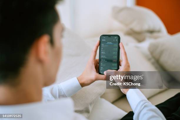 empresario analizando bolsa financiera en smartphone - stockbrokers fotografías e imágenes de stock