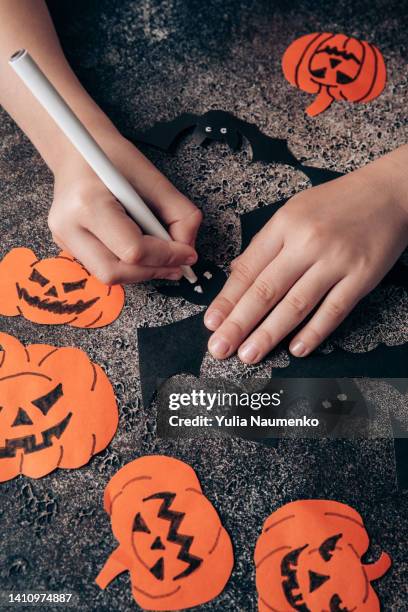 children's hands prepare decorations from paper for halloween. preparing for the holiday. - halloween craft stock pictures, royalty-free photos & images