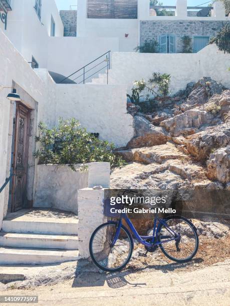 blue bike in front of a white house - dodecanese islands stock-fotos und bilder