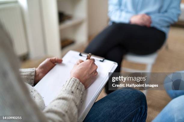 close-up of volunteer man writing notes and helping  refugee. - job centre stock pictures, royalty-free photos & images