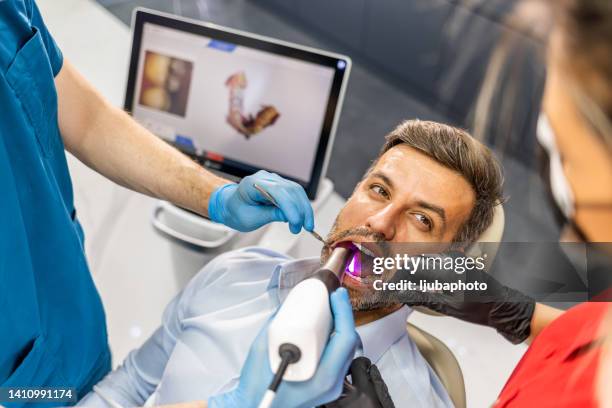 dentista que utiliza un escáner intraoral 3d para escanear los dientes de los pacientes. - medical scanner fotografías e imágenes de stock