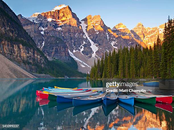 sunrise on moraine lake and colorful canoes - banff stockfoto's en -beelden