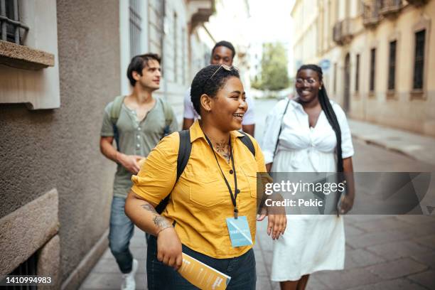 reiseleiter mit einer gruppe von menschen in der stadt - reiseführer stock-fotos und bilder