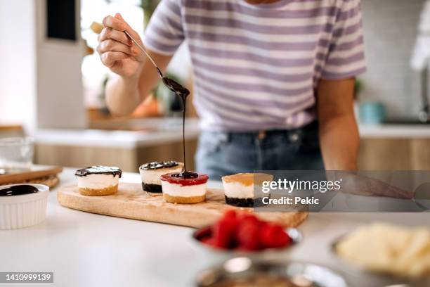 putting chocolate topping on a cakes - chocolade mousse stockfoto's en -beelden