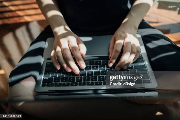 close up of female hands typing on computer keyboard in the living room at home against natural sunlight. close up of woman's hand using laptop at home. lifestyle and technology. home office. freelancer, self-employment concept - password stock-fotos und bilder