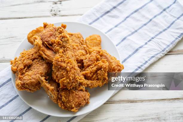 white plate of fried chicken on wood table - gefrituurde kip stockfoto's en -beelden
