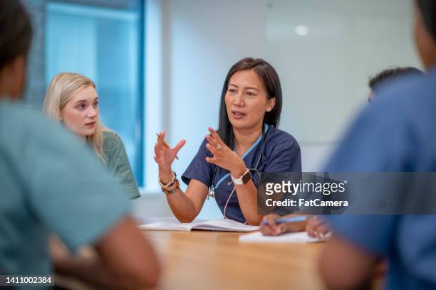 nurses meeting - four people talking stock pictures, royalty-free photos & images