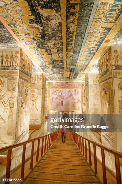 joven caminando en la tumba de ramsés v y ramsés vi (kv9), valle de los reyes, egipto - valle de los reyes fotografías e imágenes de stock
