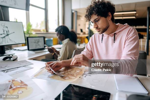 diseñadores de juegos profesionales trabajando juntos en su nuevo diseño de juegos - profesional de diseño fotografías e imágenes de stock