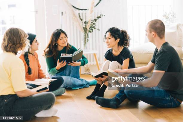 happy people discussing a new book - book club meeting stockfoto's en -beelden