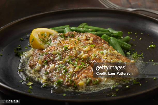 baked tilapia in a lemon, garlic and butter sauce - halibut stock pictures, royalty-free photos & images