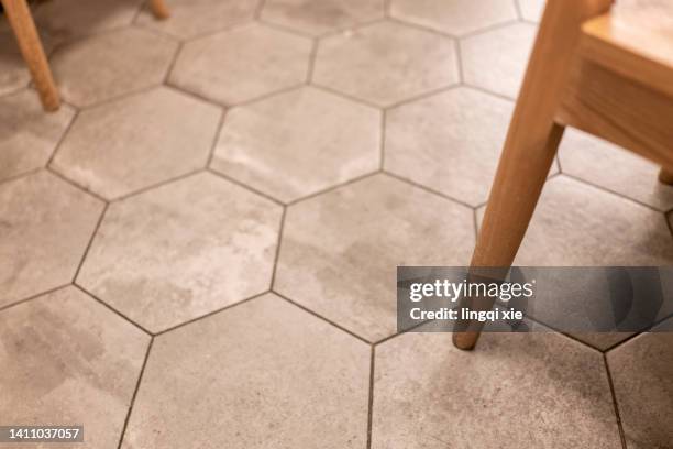 abstract pattern formed by chair legs on a floor of hexagonal tiles - legs on the table foto e immagini stock