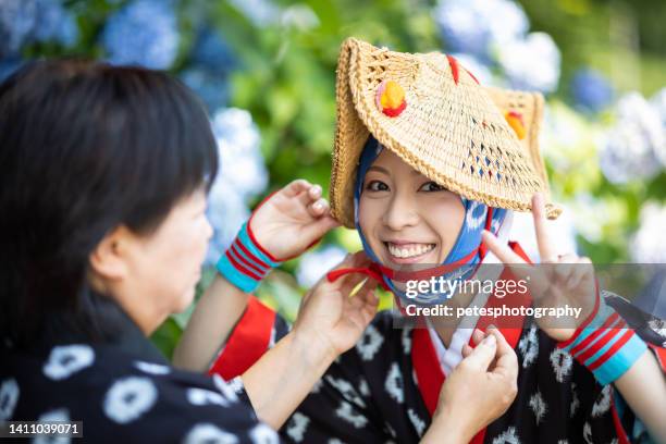 若い女性が伝統的な祭りのドレスを着るのを手伝う年配の日本人女性 - 東北地方 ストックフォトと画像