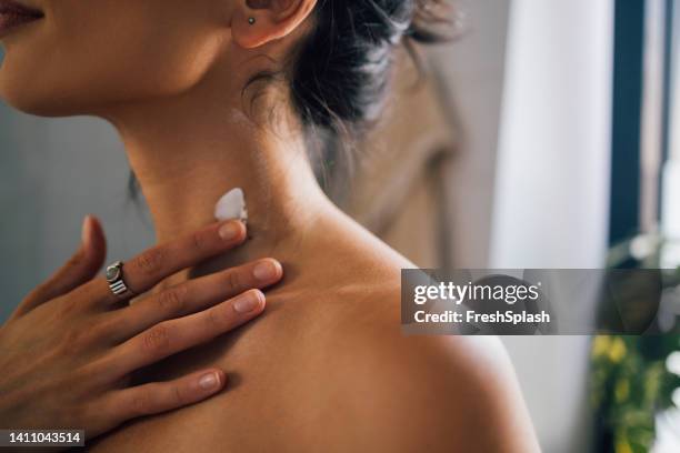eine nahaufnahme einer unkenntlich glücklichen schönen frau, die sich um ihre haut kümmert - hals stock-fotos und bilder