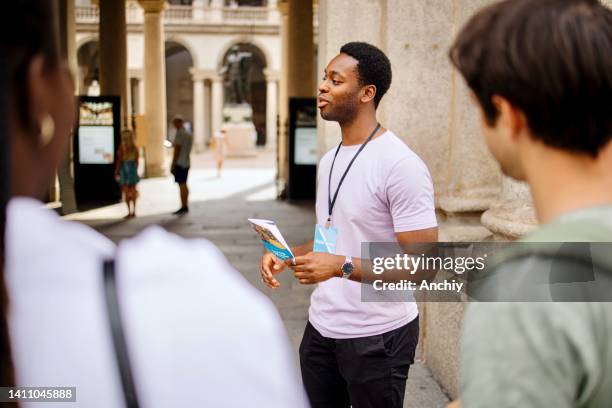 reiseleiter mit reiseführer und gesprächen über berühmte sehenswürdigkeiten der stadt - führung stock-fotos und bilder