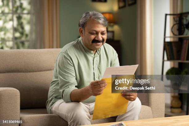 man with envelope in hands stock photo - elderly receiving paperwork stock pictures, royalty-free photos & images