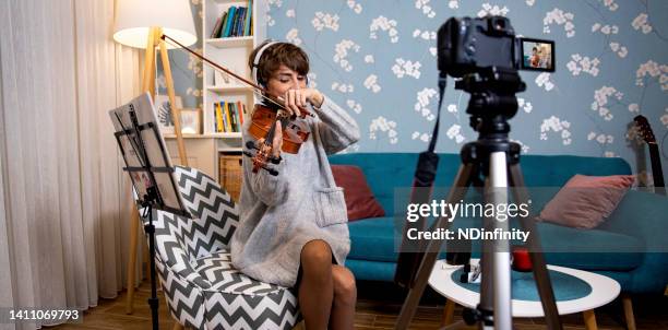 young female learns to play online from home stock photo - teach muziekinstrument stockfoto's en -beelden