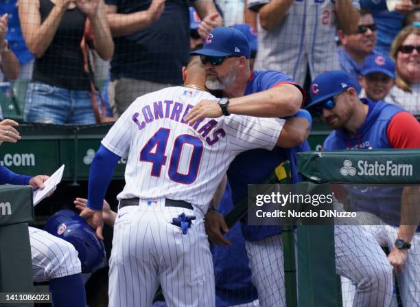 Willson Contreras of the Chicago Cubs gets a hug from manager David Ross of the Chicago Cubs after he scored during the first inning of a game...