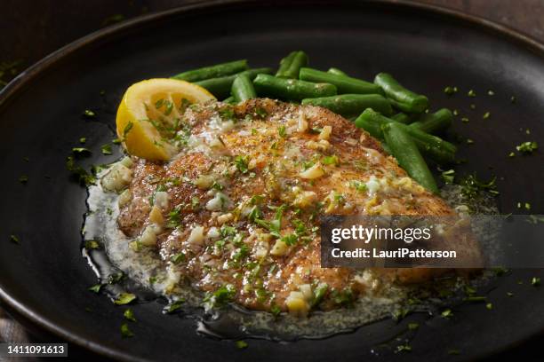 tilapia al forno in salsa di limone, aglio e burro - filetto foto e immagini stock