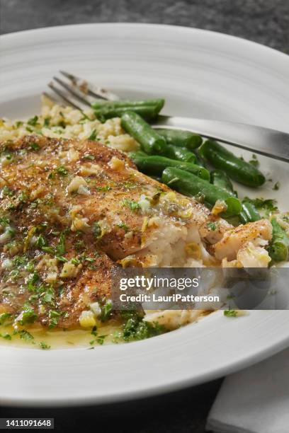 baked tilapia in a lemon, garlic and butter sauce - sears canada stock pictures, royalty-free photos & images