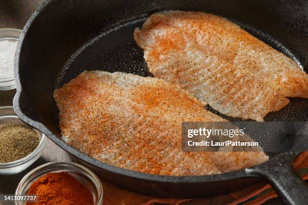 preparing tilapia in a lemon, garlic and butter sauce - haddock stock pictures, royalty-free photos & images