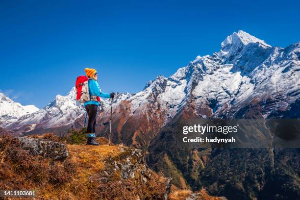 young woman looking at thamserku mountain, mount everest national park - sagarmatha national park stockfoto's en -beelden