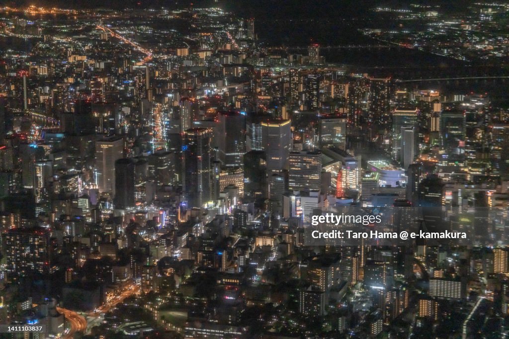 Illuminated buildings in Osaka city of Japan aerial view from airplane