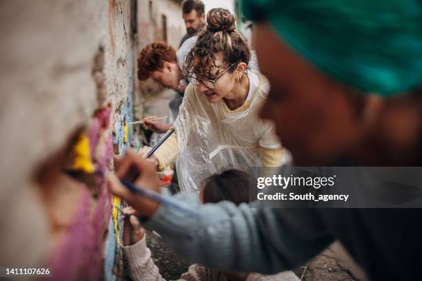 artistes de rue peignant sur le mur - peinture murale photos et images de collection