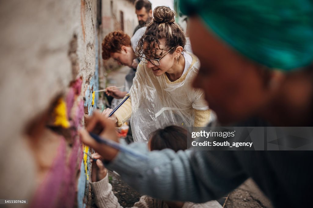 Street artists painting on wall