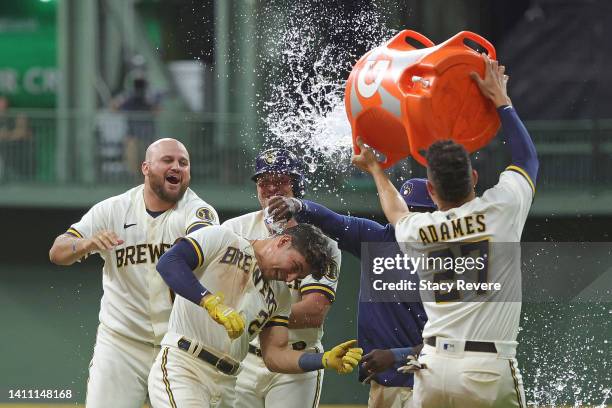 Luis Urias of the Milwaukee Brewers is congratulated by teammates after hitting a walk off game winning sacrifice fly during the ninth inning against...