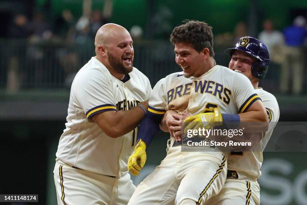 Luis Urias of the Milwaukee Brewers is congratulated by teammates after hitting a walk off game winning sacrifice fly during the ninth inning against...