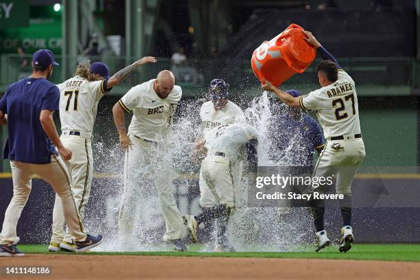 Luis Urias of the Milwaukee Brewers is congratulated by teammates after hitting a walk off game winning sacrifice fly during the ninth inning against...