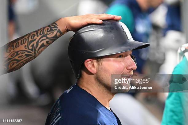 Crawford of the Seattle Mariners pats Cal Raleigh on the helmet after Raleigh''s solo home run during the seventh inning against the Texas Rangers at...