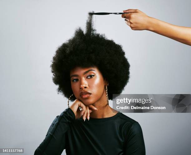 natural hairstyle and afro model symbolising proud retro culture or melanin beauty with funky and trendy hair. portrait of confident woman with attitude and stylist using volume pick or grooming comb - afro stock pictures, royalty-free photos & images