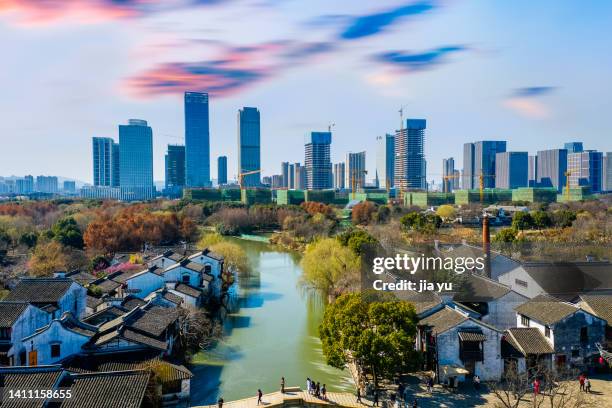 the old buildings in the ancient town and the tall buildings in the distance. wuxi city, jiangsu province, china. - ancient china stock pictures, royalty-free photos & images