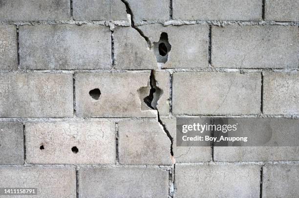 cracks on concrete wall. cracks are often caused by normal shrinkage of the concrete when hardening and drying. - concrete block stock pictures, royalty-free photos & images