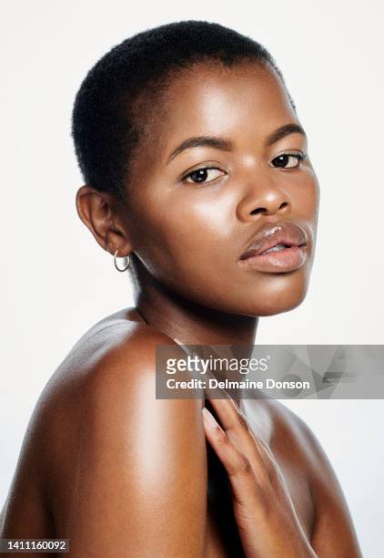 face off a beautiful young african woman with healthy skin, isolated on a white background. portrait of a serious lady embracing natural hair and beauty with good skincare products - sleutelbeen stockfoto's en -beelden