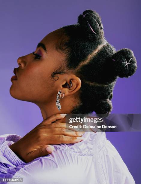 fashionable, cool and edgy woman isolated against purple studio background, posing with trendy, funky and hip hairstyle. headshot of young model with attitude wearing street style clothes and jewelry - purple jacket stock pictures, royalty-free photos & images