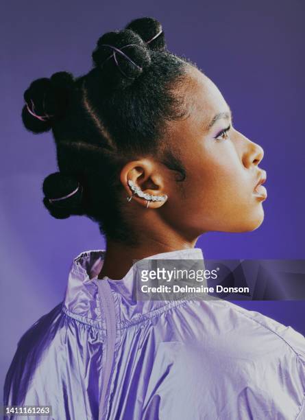 linda garota negra com nós bantu mostrando seu penteado e piercing. rosto de linda mulher africana brilhando em tons de roxo. jovem com pele impecável isolada em fundo violeta - african violet - fotografias e filmes do acervo