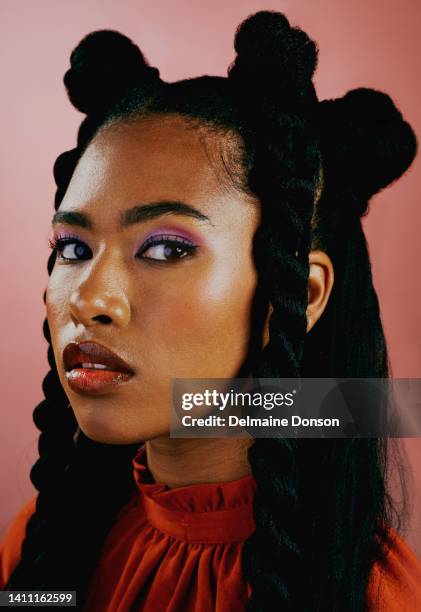 portrait of an edgy young woman wearing fashionable purple makeup and orange clothes with a trendy hairstyle against a studio background. confident female with bold personality and cool attitude - flätor bildbanksfoton och bilder