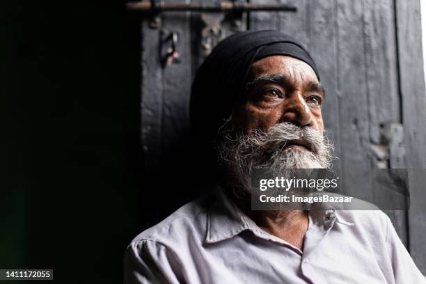 close-up of a senior sikh man sitting at home and thinking - 民族衣装 ストックフォトと画像