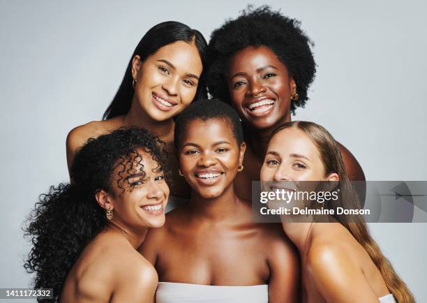 ritratto di bellezza di un gruppo eterogeneo di belle donne che sorridono insieme su uno sfondo grigio dello studio. volti di modelle con pelle e carnagione perfette e chiare da una routine quotidiana di cura della pelle - black model foto e immagini stock